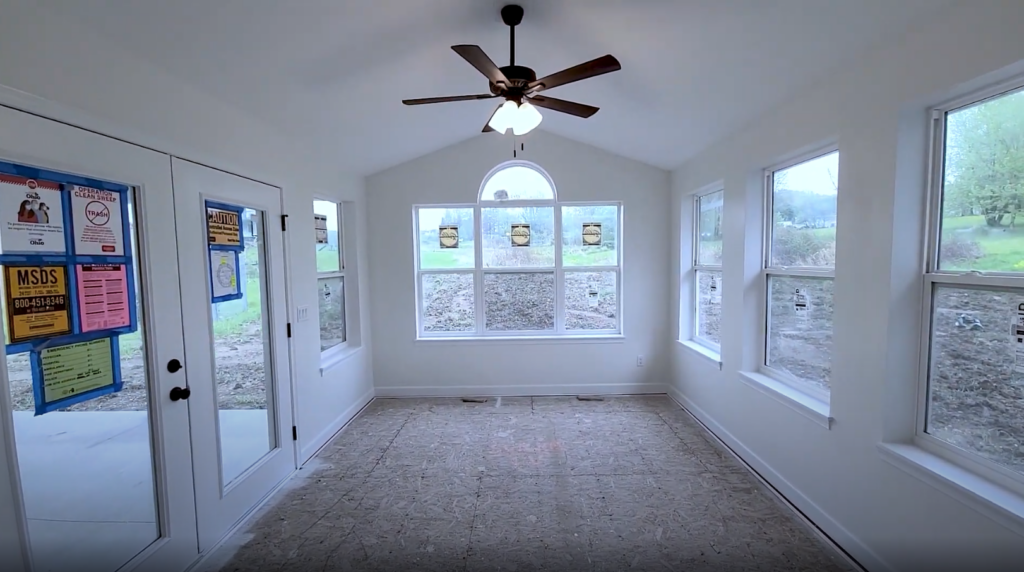 Traditional sunroom featuring a cathedral ceiling and many windows for sunlight